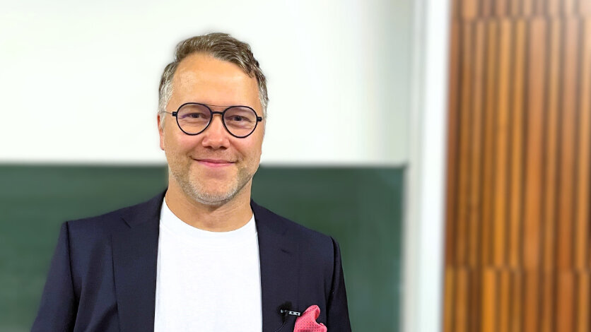 Porträtfoto eines Mannes im nachtblauen Anzug.