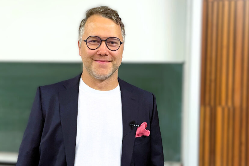 Porträtfoto eines Mannes im nachtblauen Anzug.