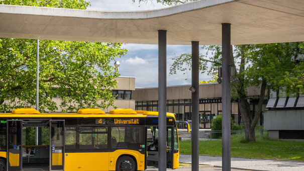 Gelber Linienbus am Busbahnhof der Universität mit dem Ziel "Universität"