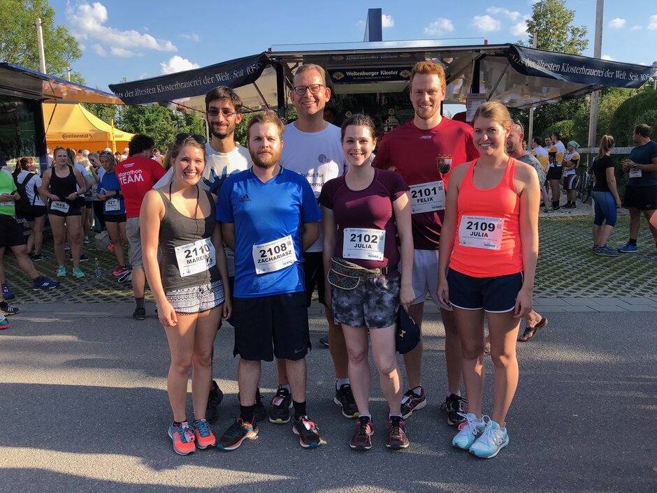 Gruppenfoto an einem sonnigen Sommertag von Prof. Kingreen und 6 Lehrstuhlmitarbeiter/-innen in Sportkleidung nach dem Lauf vor einem Getränkestand (öffnet Vergrößerung des Bildes)