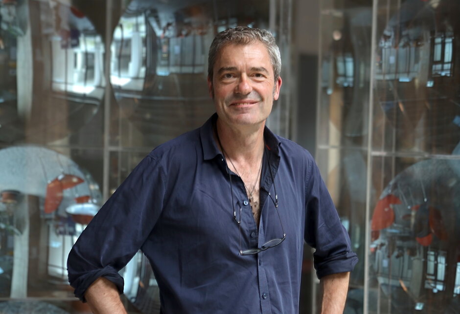 Ein Mann mit blauem Hemd vor unscharfem Hintergrund