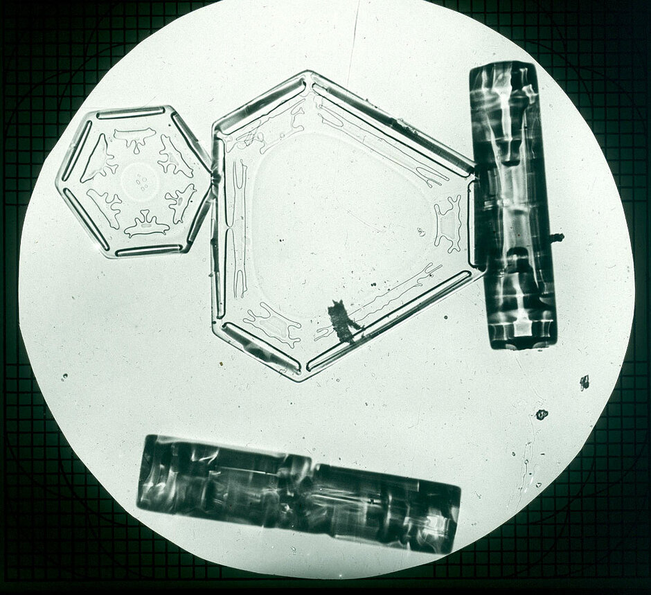 Hexagonaler und dreieckiger Schneekristall neben hohlen hexagonalen Prismen (öffnet Vergrößerung des Bildes)