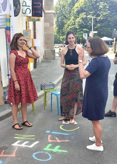 Drei Frauen in Sommerkleidung unterhalten sich. (öffnet Vergrößerung des Bildes)