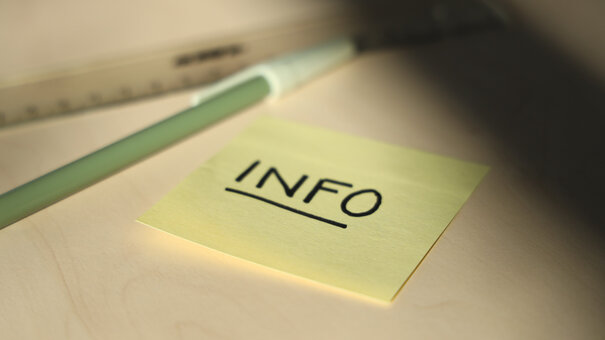 gelber Zettel, auf dem "Info" steht. Daneben liegt ein Stift und ein Lineal.