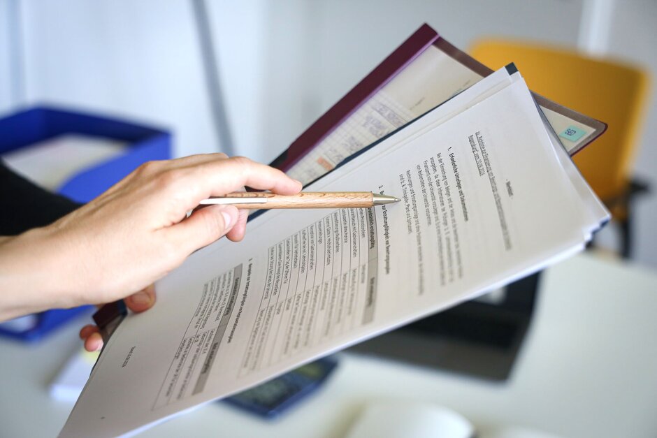 Eine Person zeigt auf ein Dokument.