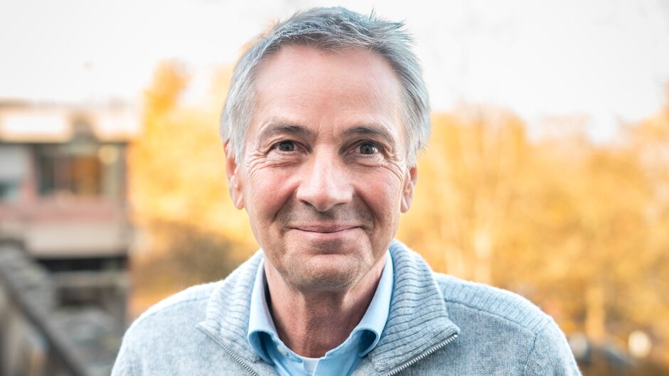 [Translate to English:] Mann schaut in die Kamera