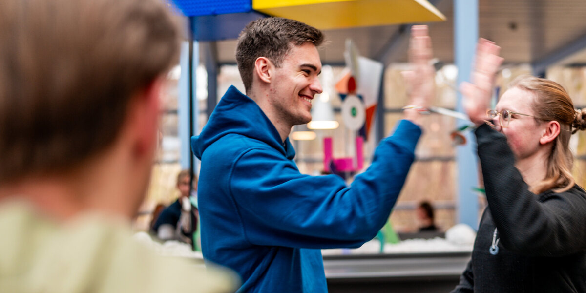 Zwei Studenten klatschen sich mit der Geste "High Five" ab.