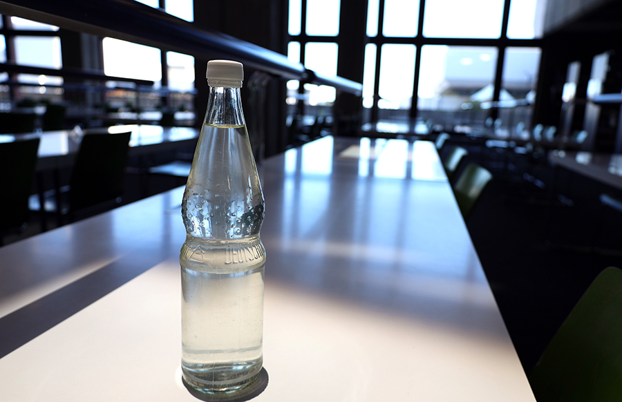 Gefüllte Wasserflasche steht auf Tisch im Lesesaal