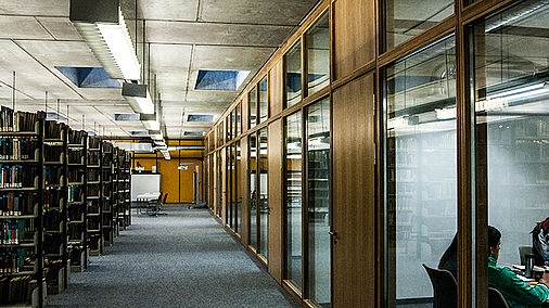 Links Bücherregale, rechts geschlossene Gruppenarbeitsräume