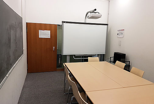 Gruppenarbeitsraum mit SMART Board, im Vordergrund Tisch und Stühle