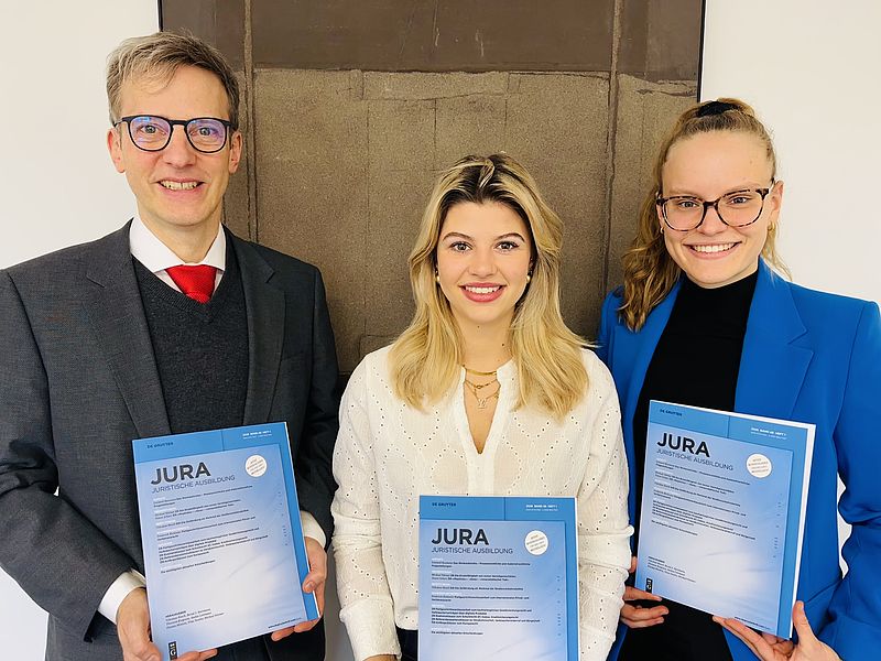 Das Bild zeigt den Lehrstuhlinhaber, Prof. Dr. Bernd J. Hartmann, LL.M. (Virginia), seine wissenschaftliche Mitarbeiterin Laura Macketanz, sowie Frau Luisa Oberloher, von der die Klausurlösung im neuen Heft der JURA stammt.