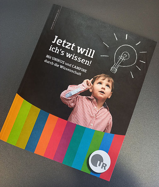 Der Flyer zu "Jetzt will ich´s wissen! Mit Unikus und Campine durch die Wissenschaft." Darauf abgebildet iist ein Junge mit einer gezeichneten Glühbirne über dessen Kopf.