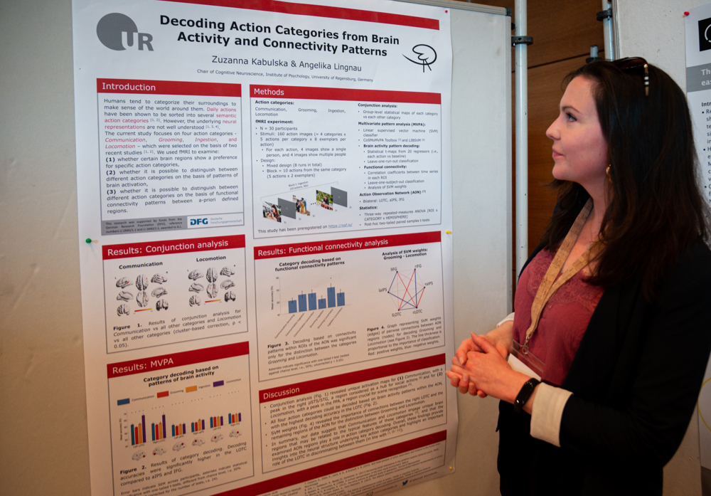 A young woman explains a scientific poster.