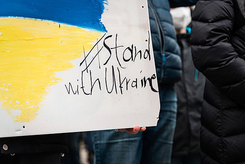 Wooden sign with the Ukrainian flag and the words #stand with ukraine