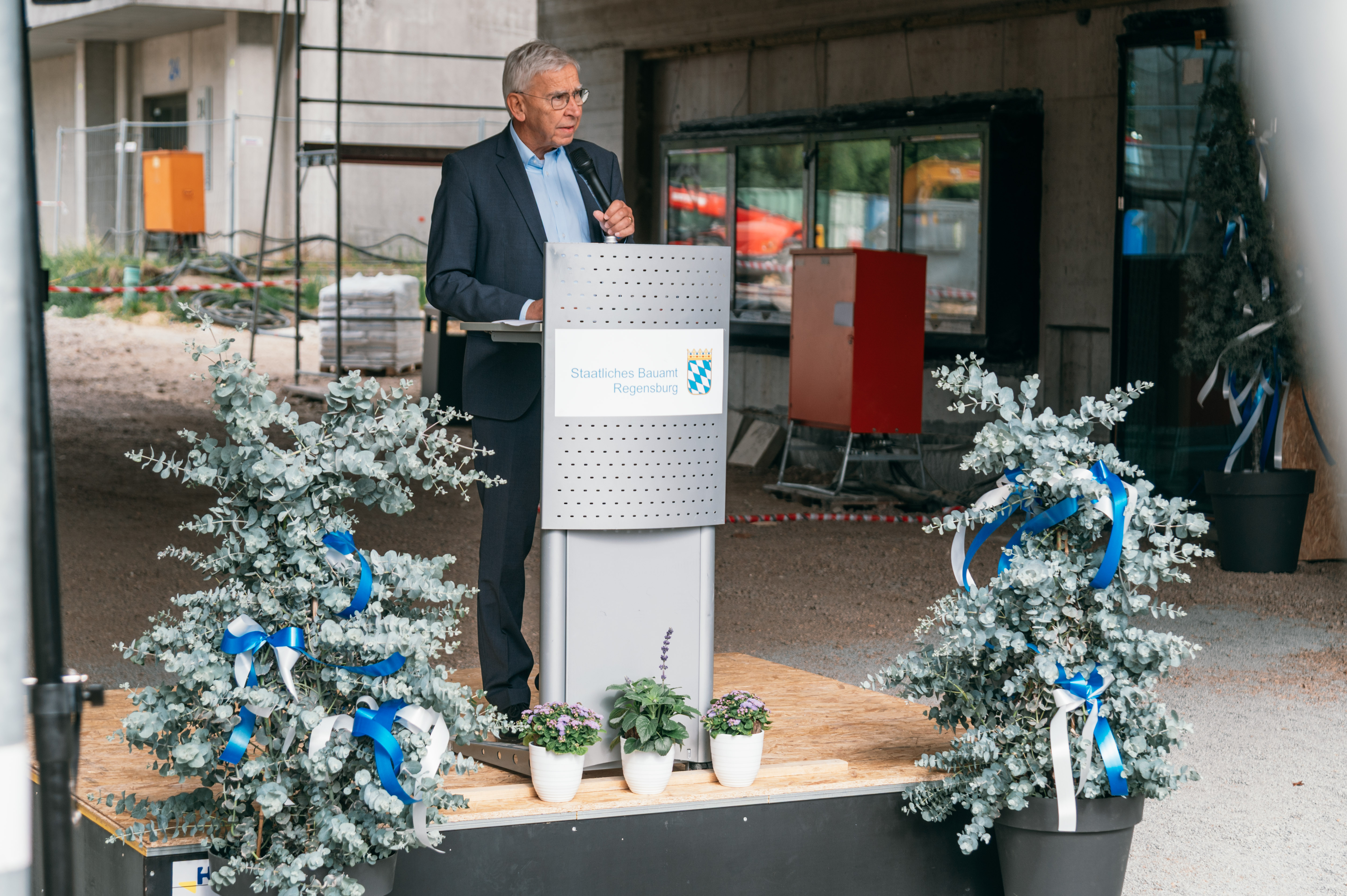 Ein Mann mit grauen Haaren steht an einem Rednerpult und spricht. (öffnet Vergrößerung des Bildes)