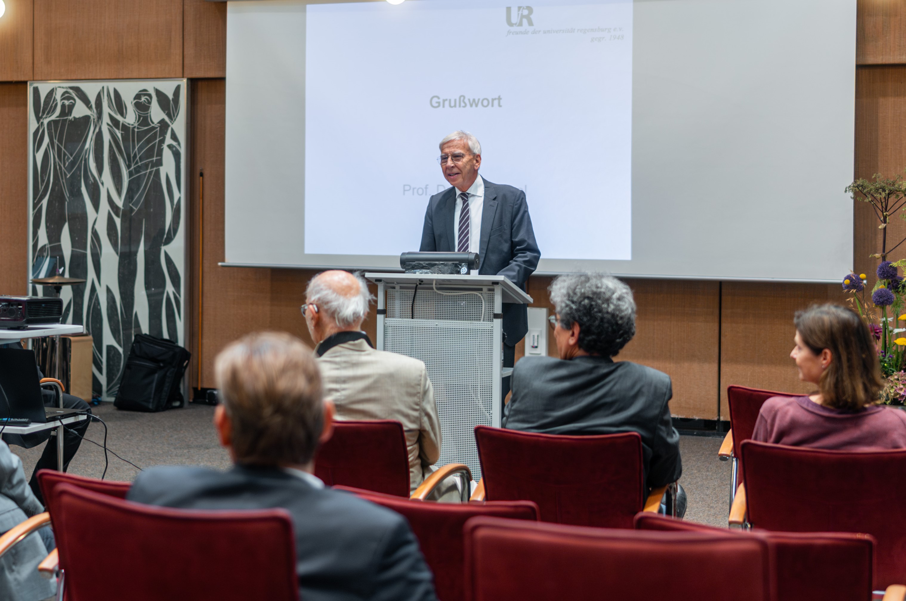 Ein Mann mit weißen Haaren steht an einem Rednerpult. (öffnet Vergrößerung des Bildes)