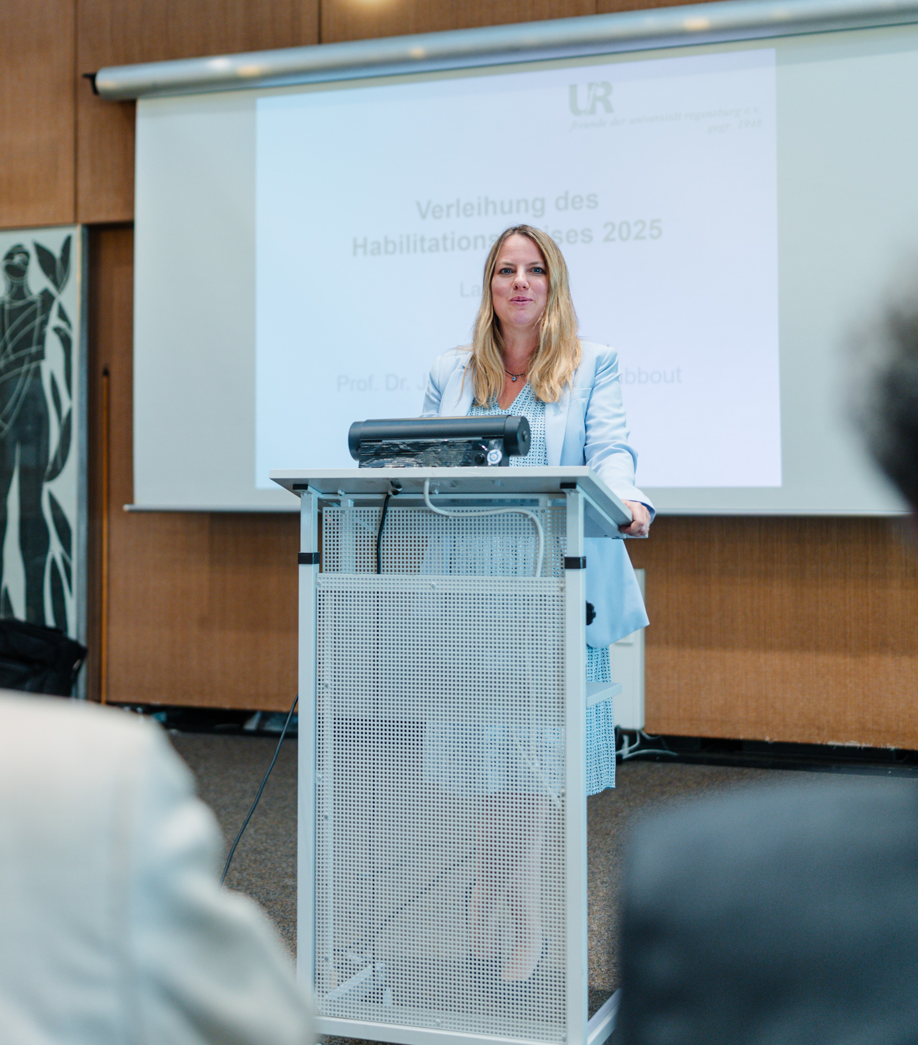 Eine Frau steht an einem Rednerpult. (öffnet Vergrößerung des Bildes)