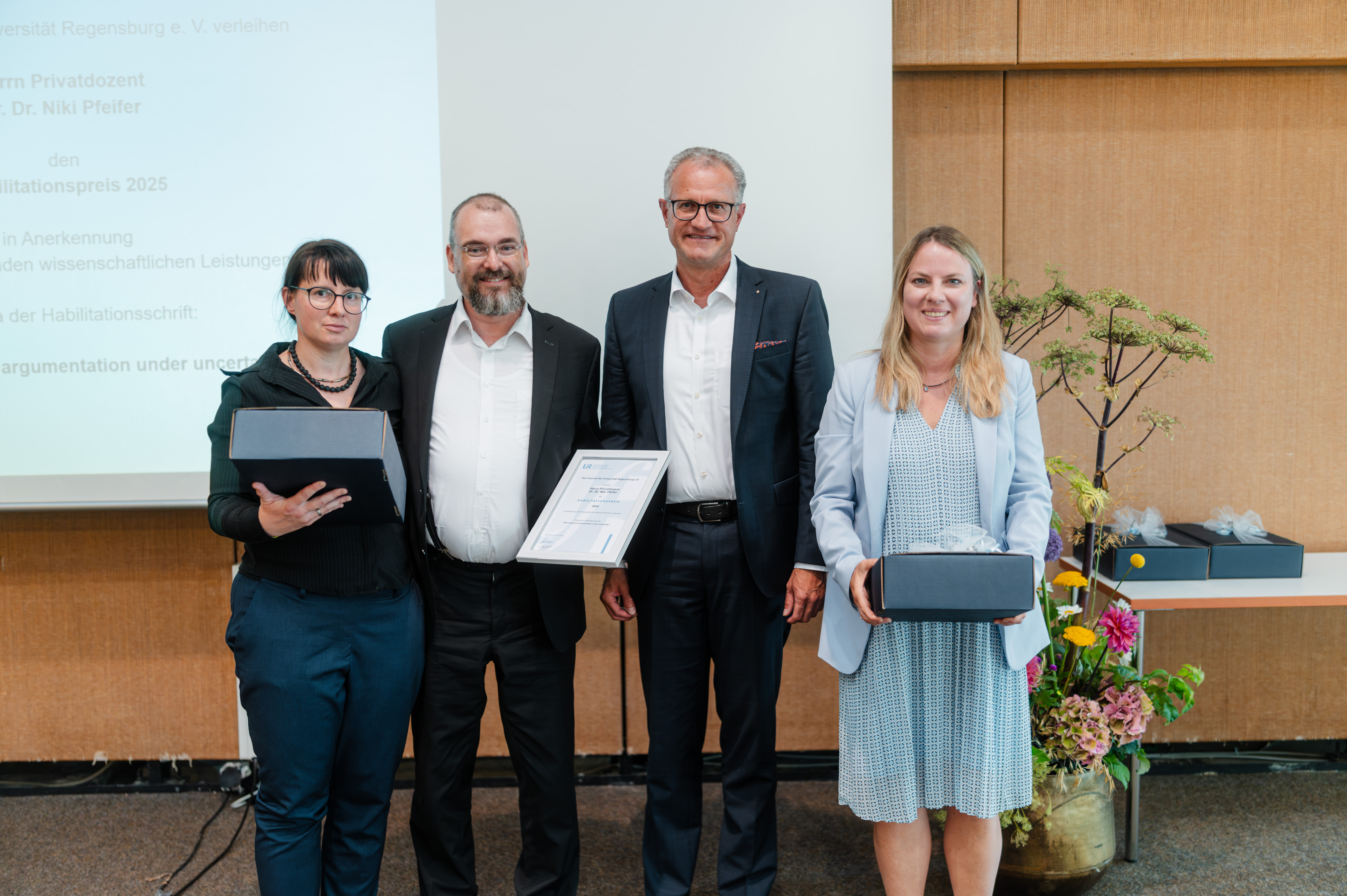 Zwei Frauen und zwei Männer lächeln in die Kamera. (öffnet Vergrößerung des Bildes)