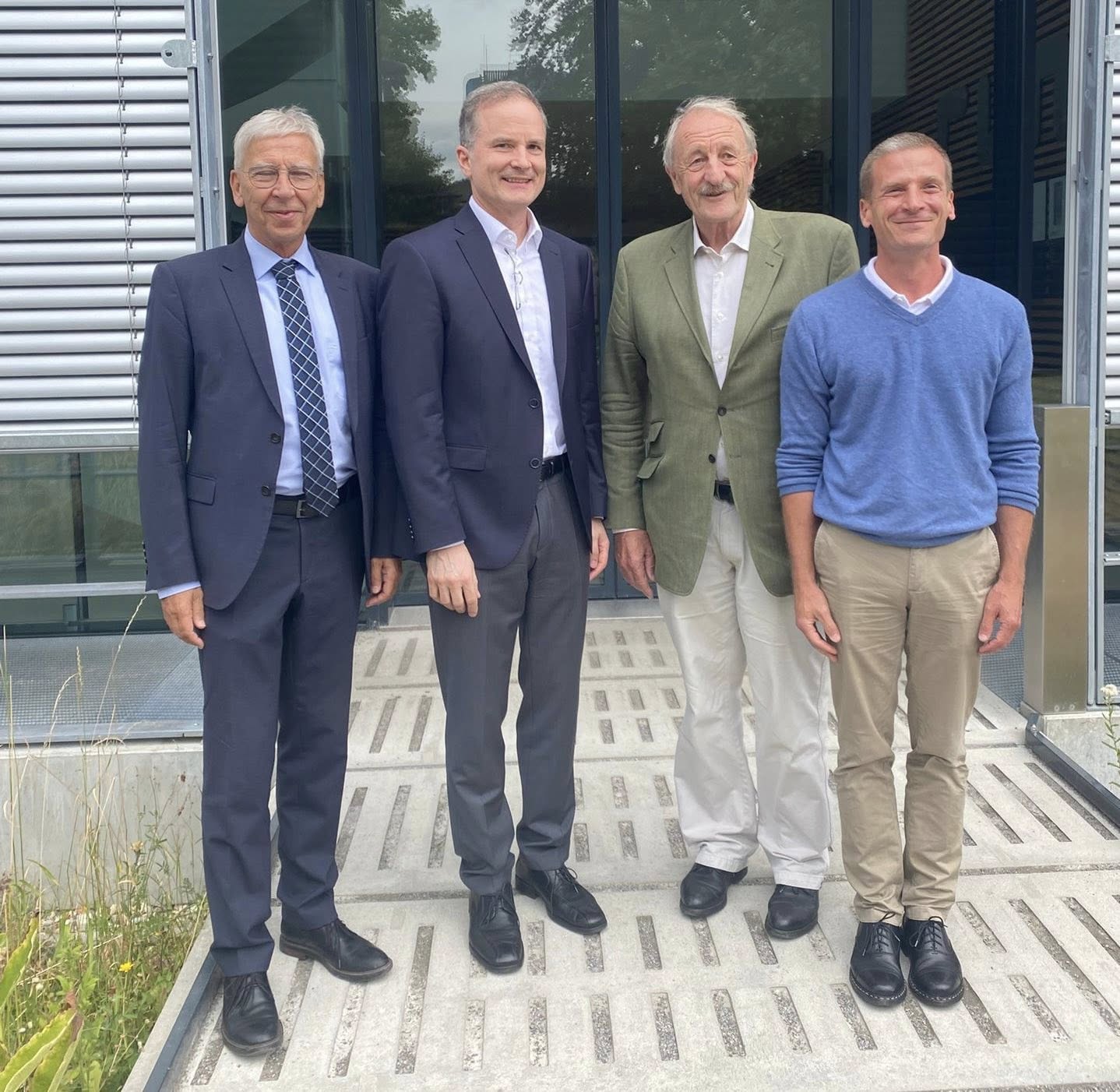 Vier weiße Männer mittleren Alters lächeln vor dem Eingang des RUN in die Kamera. (öffnet Vergrößerung des Bildes)