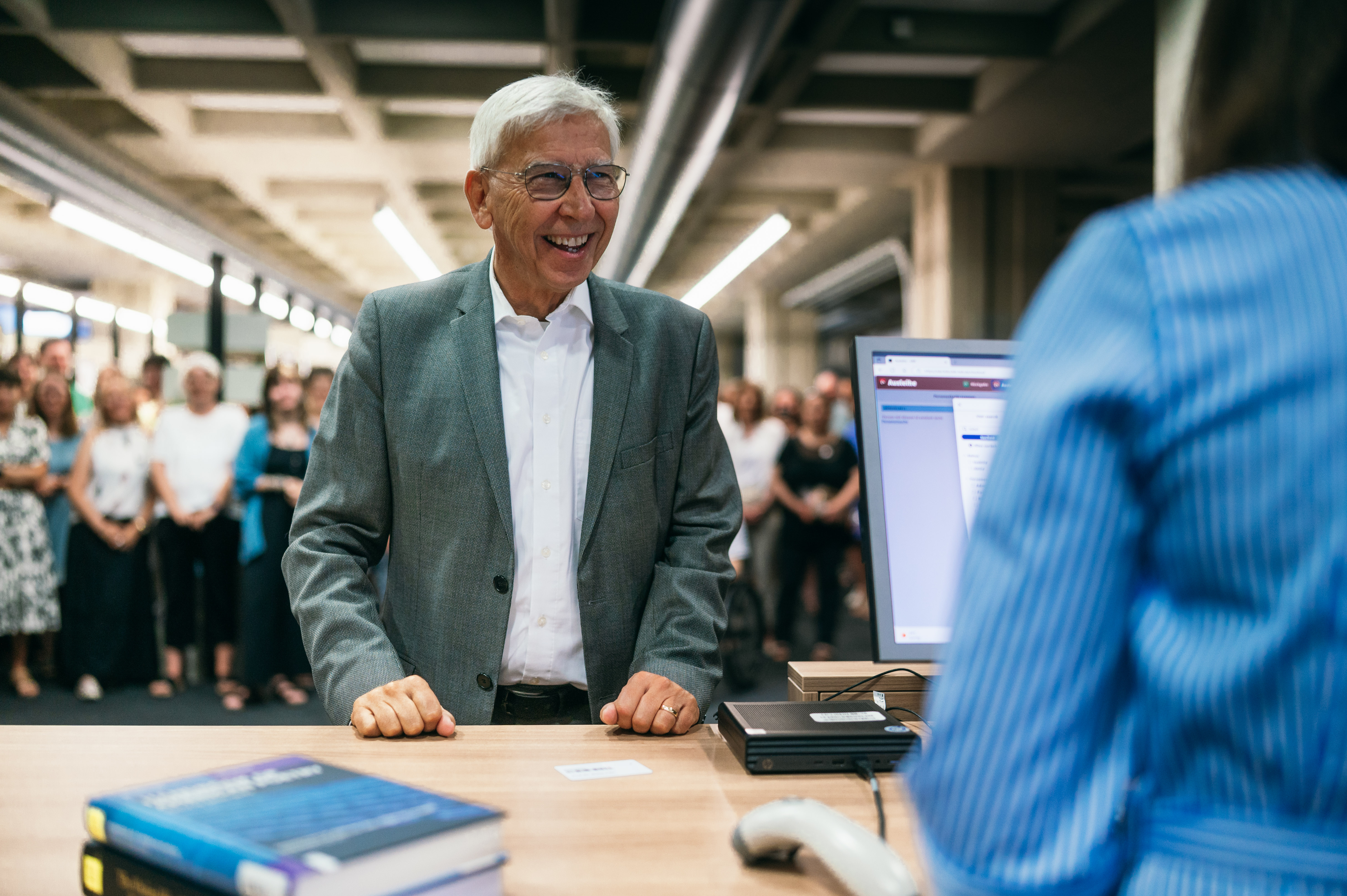 Mann an Schalter, lächelnd. (öffnet Vergrößerung des Bildes)