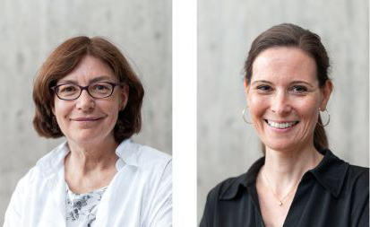 Auf dem Bild sind zwei Frauen zu sehen: Links eine freundliche Frau in weißer Bluse mit Brille und kinnlangen, brünetten Haaren. Rechts eine freundliche junge Frau in schwarzer Bluse mit Creolen-Ohrringen und brünetten, langen Haaren, die sie zusammengebunden hat.