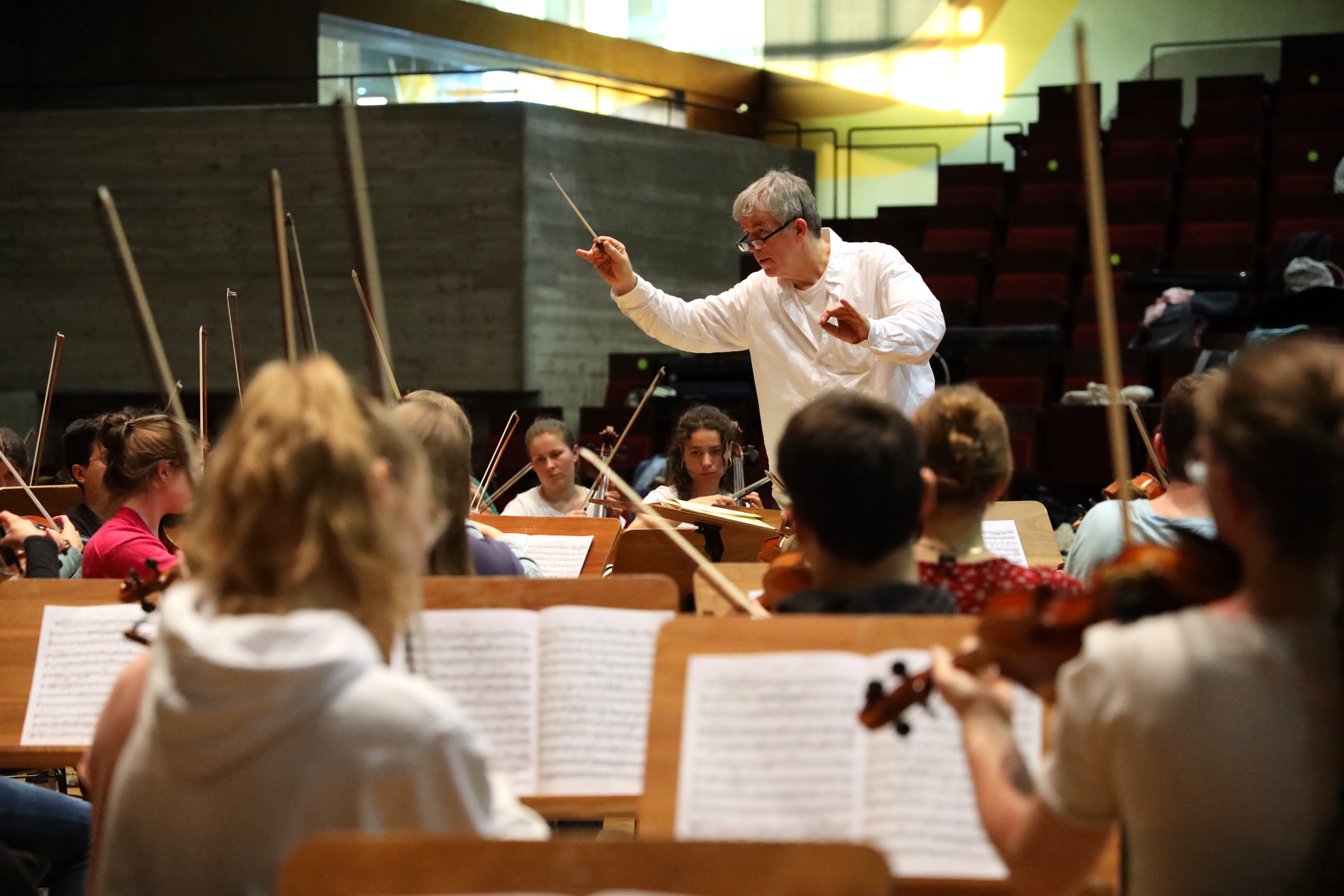 Ein Dirigent dirigiert ein Symphonieorchester.